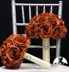 the bridal bouquet is made up of orange roses and an ivory pipe with diamond brooches