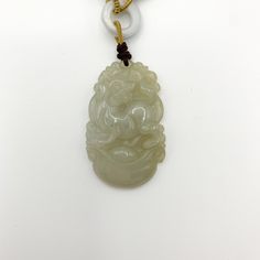 This is a high grade jadeite jade pendant necklace. It is exquisitely hand carved, so each pendant is different in some way. The pendant is completely natural jade, un-dyed and in its natural form. The pendant is carved in the form of the Chinese Zodiac - Dog. The beads above the pendant on the necklace are natural hand carved jadeite jade beads. They may not be perfectly round because they are hand carved. This gives the necklace a more rustic and natural stone like look. The years of the Dog i Jade Amulet Pendant Necklace, Engraved Jade Amulet Jewelry, Carved Jade Pendant Jewelry, Carved Jade Pendant Necklace, Carved Jade Jewelry For Good Luck, Dog Chinese Zodiac, Red Pendant Necklace, Red Pendant, Jade Pendant Necklace