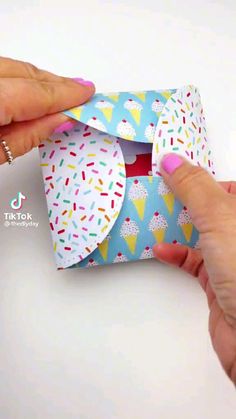 someone is holding an origami box with sprinkles on it