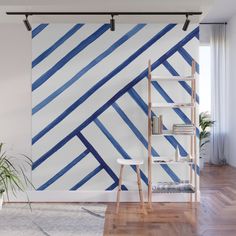 a blue and white striped wall mural in a living room with wooden floors, bookshelf