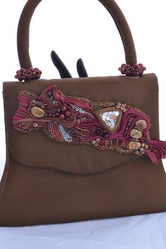 Beautifully beaded and embellished Shibori Ribbon accents this caramel brown handbag with shades of burgandy, antique gold and crystal, including a large Swarovski Triangle in Crystal. Baroque gold pearls add accents, along with burgandy pearls, more Swarovski crystals in various shades, along with beaded beads for the handle. Perfect with a little black dress, or a vintage ensemble, this purse will make a great gift, even if its for yourself! Hand beaded by me in my Las Vegas studio, this handb Traditional Brown Shoulder Bag For Formal Occasions, Formal Brown Handmade Bags, Traditional Brown Formal Bag, Elegant Handmade Brown Shoulder Bag, Handmade Brown Shoulder Bag For Evening, Embellished Brown Shoulder Bag For Party, Evening Handmade Brown Shoulder Bag, Evening Brown Handmade Shoulder Bag, Designer Brown Bag For Party