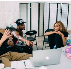 two people sitting at a table with laptops