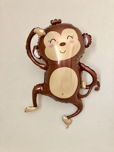 a balloon shaped like a monkey hanging on the wall