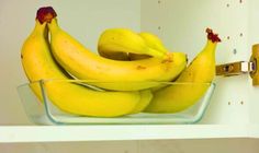 a glass bowl filled with bananas on top of a shelf