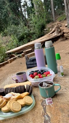 a picnic table is set up with food and drinks on it, along with other items