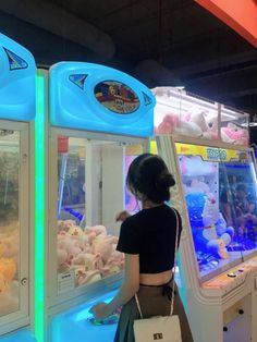 a woman looking at stuffed animals in an arcade