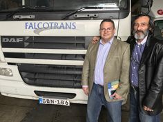 two men standing next to each other in front of a white truck with the words falconrans on it