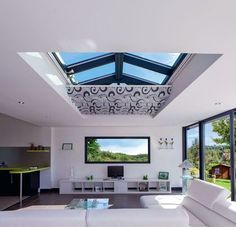 a living room filled with furniture and a flat screen tv mounted to the wall above it