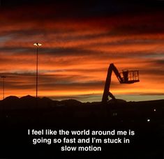 an orange and black sky with a silhouette of a crane in the foreground that reads, i feel like the world around me is going so fast and i'm stuck in slow motion