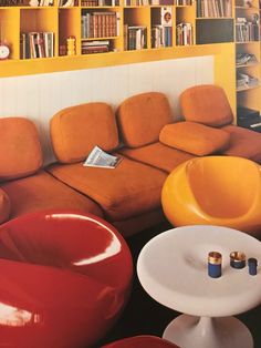 a living room filled with furniture and bookshelves next to a wall full of books