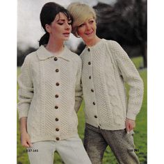 two women standing next to each other wearing sweaters and pants with buttons on them