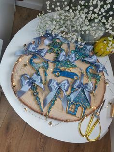 there is a cake decorated with blue ribbons and bows on the table next to scissors