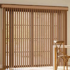 a dining room with wooden blinds in the window and a table on the floor next to it