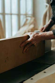 a man is working on some wood with his hands