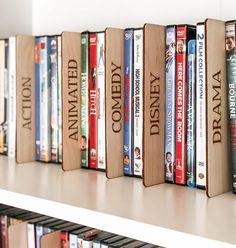 a row of books sitting on top of a white book shelf next to each other