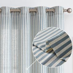 a close up of a blue and white striped curtain with metal hardware on the side