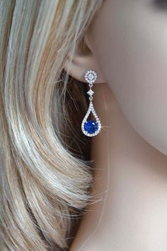 a pair of blue and white earrings on top of a mannequin's head