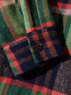 a close up view of the collar and cuffs of a plaid shirt with buttons on it