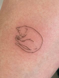 a small cat tattoo on the thigh