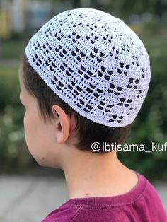 a young boy wearing a white crochet hat