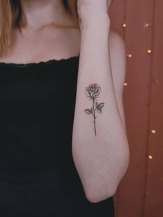 a woman with a rose tattoo on her arm