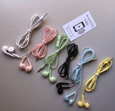 several earbuds laying on top of a table next to a tag with the name headphones