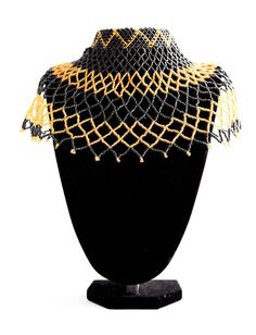 Big black and gold African beaded tribal chest piece choker statement necklace.One-of-a-kind and handmade by the Maasai Tribe in Kenya.Made from black and gold Maasai beads.Measuring approximately 54 cm across and 19 cm long.The choker top measures 27 cm with a beaded clasp, adding up to an additional 5 cm with the 2 different adjustable sizes.A serious statement piece.Fit for an Empress. Traditional Black Jewelry With Bead Caps, Black Festival Choker With Large Beads, Festival Black Choker With Large Beads, Traditional Black Choker With Colorful Beads, Bohemian Black Choker With Large Beads, Gold Beaded Necklaces With Black Beads For Festivals, Gold Beaded Necklace With Black Beads For Festivals, Traditional Black Round Beads Choker, Traditional Black Beaded Choker Necklace