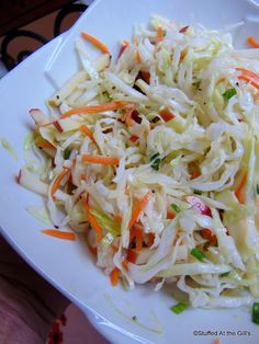 a white plate topped with coleslaw and carrots