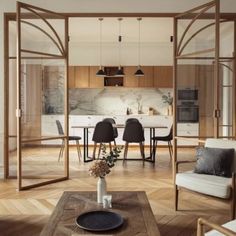 a living room filled with furniture next to a kitchen and dining room table on top of hard wood flooring