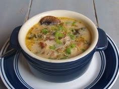 a blue and white plate topped with a bowl of soup