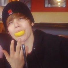 a young man eating a banana while sitting in a booth at a fast food restaurant