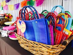 a basket filled with lots of colorful bags on top of a table next to other items