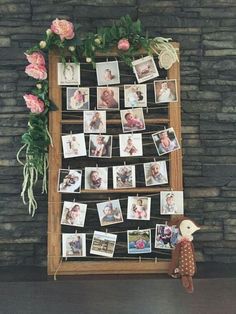 a wooden frame with pictures and flowers on it next to a stuffed animal toy in front of a stone wall