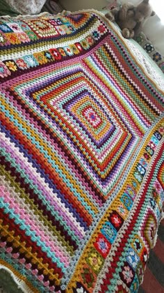 a crocheted blanket is laying on a bed