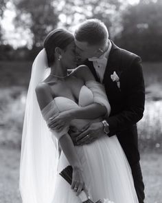 a bride and groom embracing each other in black and white