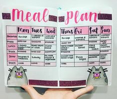 someone is holding up a meal plan book