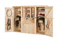 a wooden shed with several horse tacks and saddles on the outside, including one door open