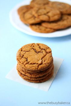 several cookies are stacked on top of each other in front of a plate with one cookie