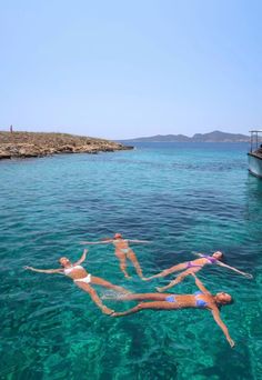 three people floating in the water near a boat