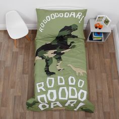 a bed with a green dinosaur print on it