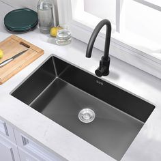 a kitchen sink sitting on top of a counter next to a cutting board and knife