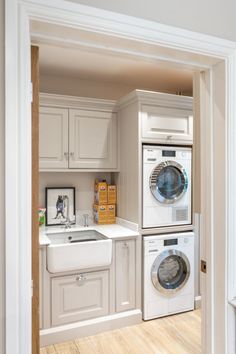 a washer and dryer sitting in a kitchen next to each other on top of a wooden floor