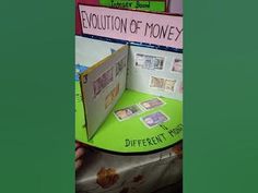 there is an open book on display with different types of money in the front and back