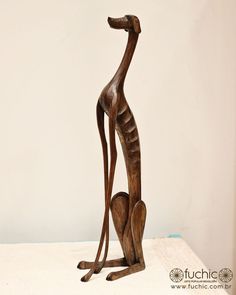 a wooden statue of a giraffe with its baby in it's lap