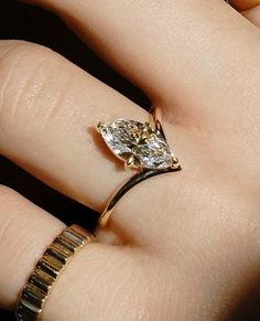 a woman's hand with a ring on it and a diamond in the middle