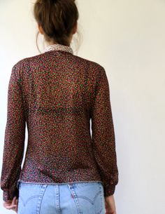 "Lovely vintage 70s floral blouse in black with floral print in pink red yellow and green, buttons down, neck tie, polyester, somewhat sheer, original tag intact, aside from minor signs of wear, good vintage condition, clean, ready to wear.** Model is 5'8\" and size S for reference Tag size: 44 Approximate size: S/M - please refer to the measurements M E A S U R E M E N T S -were taken with garments laying flat, please double where necessary. ------------------------♥-------- Bust: 18.5\"- 47 cm Gold Silk Dress, Tie Neck Shirt, 70s Floral, 70s Boho, Batik Dress, Pink Collar, Pink Collars, Boho Maxi, Silk Skirt