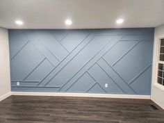 an empty room with blue walls and wood floors