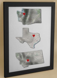 three framed maps with red hearts in the shape of heart shapes on white paper and black frame