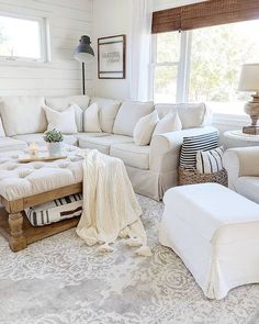 a living room with white couches and pillows