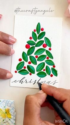 someone is painting a christmas tree on a piece of paper with watercolor pencils